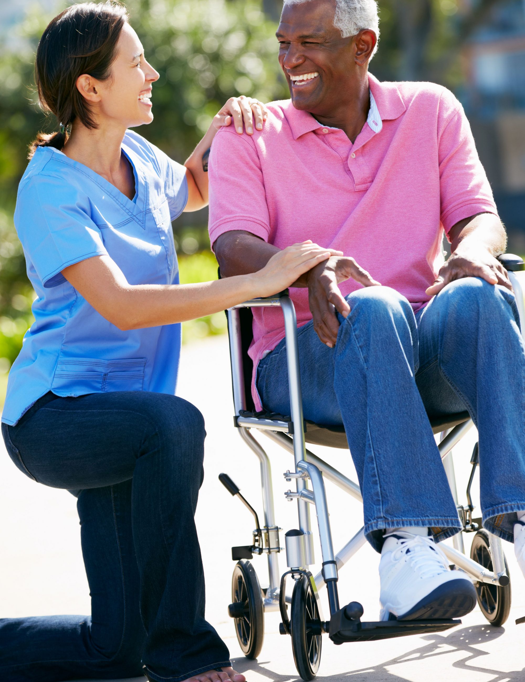 Carer Pushing Senior Man In Wheelchair